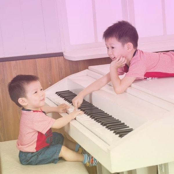 Kids playing white piano